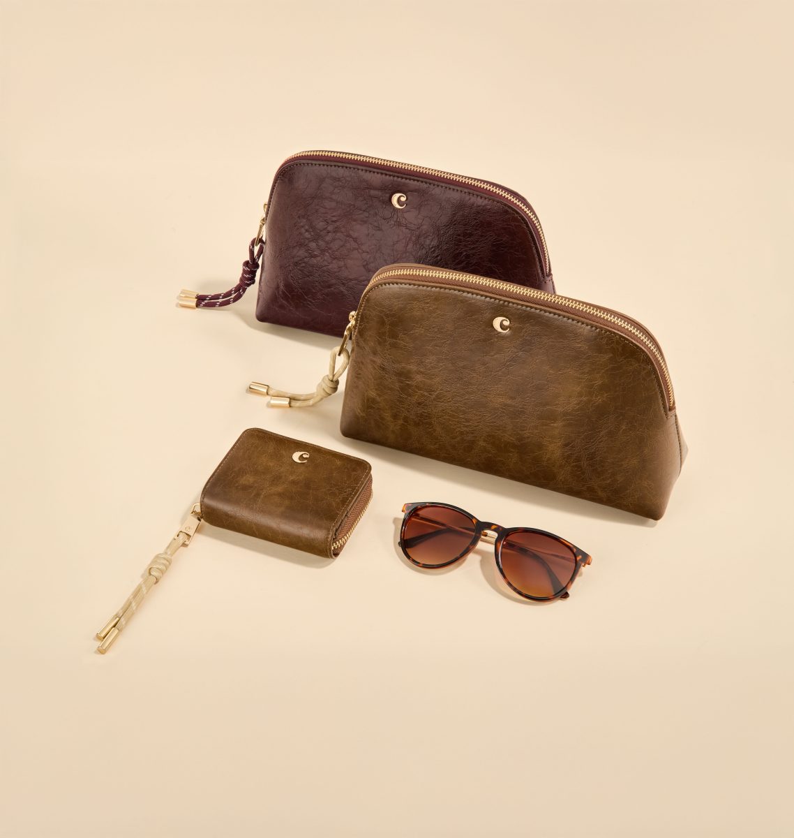 Vanity cases in burgundy and bronze with a card holder and sunglasses — Cacharel