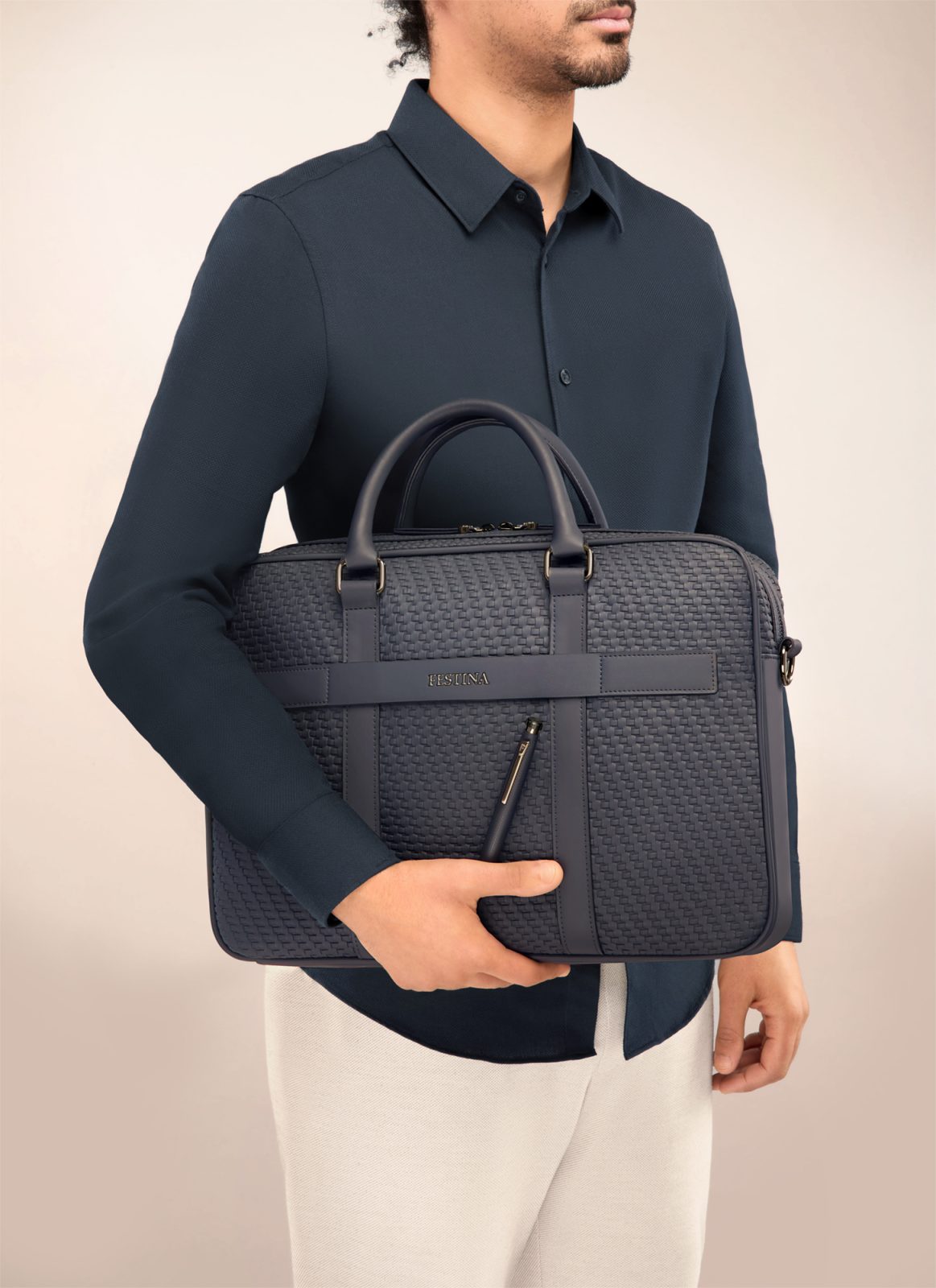 A model carrying a navy quilted briefcase — Festina